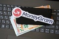 TERNOPIL, UKRAINE - SEPTEMBER 6, 2022 MoneyGram paper logotype lies on black laptop with euro bills. Moneygram is American cross