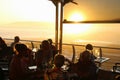 Terrace of a beach restaurant and guests in sunset light. South Africa.