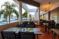 Terrace with dining tables at all-inclusive resort, view of hotel grounds with swimming pools and palm trees, Europe, Greece