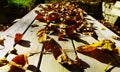 Rustic garden table made of wooden boards full of withered autumn leaves 2
