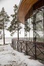Enclosed glass terrace of modern restaurant on lake shore in beautiful winter snow.Architecture, modern building, view to the