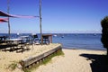 Terrace oyster restaurant seaside with empty chairs and wood table on beach village of l`herbe in Cap Ferret France Royalty Free Stock Photo