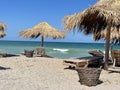 Beach in Vama Veche resort, with wooden sunbeds and reed umbrellas