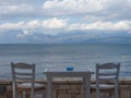 Terrace view with wooden gray table and two gray chairs, sea, cl