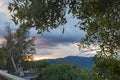 Terrace wall with garden foliage overlooking hillside and expansive sunset