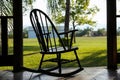Terrace with wooden rocking chair near green lawn on sunny day Royalty Free Stock Photo