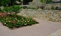 Terraces with stairs in a sloping park. stone retaining walls with light stone. blue lavender and pink roses with perennials grow Royalty Free Stock Photo