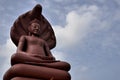 Terracotta Buddha in a blue sky.