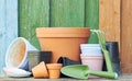 Terracotta clay flower pots with black plastic containers and garden tools on wooden table Royalty Free Stock Photo