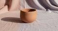 Terracotta cup on a textured, light-colored Royalty Free Stock Photo