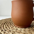 Terracotta mug with a smooth textured surface and subtle grooves, placed on a Royalty Free Stock Photo