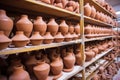 terracotta pottery on shelves waiting for glaze