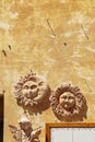 Terracotta sun and moon wall decor on rustic yellow wall Royalty Free Stock Photo