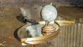Terrestrial globe placed on an eye-shaped mirror, itself placed on the ground