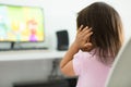 A terrified child, afraid of the loud sounds from the television. Autism