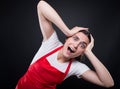 Terrified girl with apron holding her head