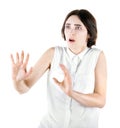 A terrified girl isolated on a white background. A scared girl protecting herself. Lady in a white blouse. Emotional young woman.