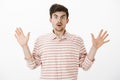 Terrified hostage afraid of being shot. Portrait of intense shocked european man with beard, raising palms in surrender