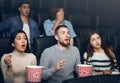 Scared young people watching new motion picture in movie theater Royalty Free Stock Photo