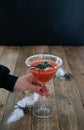 Terrifying red cocktail with spider on black background and wooden Halloween table with decoration. Vertical