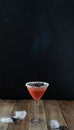 Terrifying red cocktail with spider on wooden background for Halloween. Vertical photo