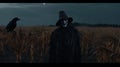Terrifying scene of a masked man in the middle of a wheat field in the middle of the night.