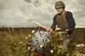 Territorial army member fighting with model of coronavirus virion outdoor on meadow