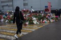 People carry flowers, candles, toys to a spontaneous memorial near the Crocus City Hall building