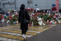 People carry flowers, candles, toys to a spontaneous memorial near the Crocus City Hall building