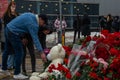 People carry flowers, candles, toys to a spontaneous memorial near the Crocus City Hall building