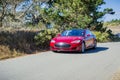 Tesla Model S car cruising on a coastal road, California