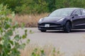 Tesla model 3 spacex edition. Black electric sports car drives at high speed into a road corner Royalty Free Stock Photo