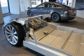 Tesla plug-in electric car chassis in front of Tesla Model X