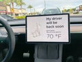 A Tesla set on dog mode to keep the air conditioning on for the car owners canine companion while they are parked in a parking lot Royalty Free Stock Photo