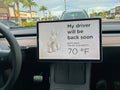 A Tesla set on dog mode to keep the air conditioning on for the car owners canine companion while they are parked in a parking lot Royalty Free Stock Photo