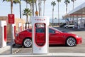 Tesla supercharger station in Central California, gas station in background Royalty Free Stock Photo