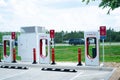 Tesla Supercharger Station in large gas station parking lot, high-voltage direct current DC fast-charging network of USA electric