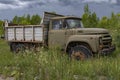 Abandoned Soviet Russian dump truck ZiL-130D (MMZ-554) in the grass