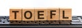 The Test of English as a Foreign Language, TOEFL - words from wooden blocks with letters, TOEFL concept, black keyboard