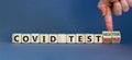 Test result of a Corona test. Male hand turns cubes and changes the expression `covid test positive` to `covid test negative`.