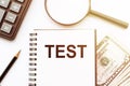 TEST text on notepad with with calculator, pencil and magnifier on the white background Royalty Free Stock Photo