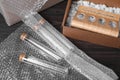 Test tubes with bubble wrap and cardboard box on dark wooden table Royalty Free Stock Photo