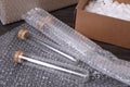 Test tubes with bubble wrap and cardboard box on table, closeup Royalty Free Stock Photo