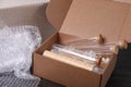 Test tubes in cardboard box and bubble wrap on dark wooden table Royalty Free Stock Photo