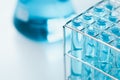 Test tubes and erlenmeyer flask filled with blue sample chemicals in chemistry science laboratory. Glassware in medical research. Royalty Free Stock Photo