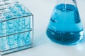 Test tubes and erlenmeyer flask filled with blue sample chemicals in chemistry science laboratory. Glassware in medical research. Royalty Free Stock Photo