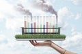 Test tubes filled with differently colored liquids, two tubes spouting smoke, standing on grass-covered screen of Royalty Free Stock Photo