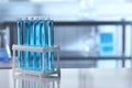 Test tubes with light blue liquid on table in laboratory. Space for text Royalty Free Stock Photo