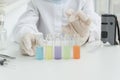 Test tubes with multi-colored liquids in front and blured hands of young scientist,