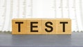 TEST word made with building blocks. Test on wooden cubes on grey notepad. Business concept